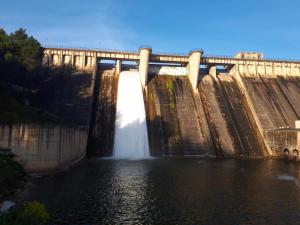 a dam with water shooting out of it at Valle Del Río Piedra in Carenas