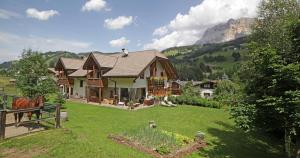 a house with a horse standing in a yard at Aria d' Prè in Badia