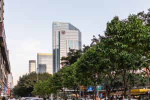 een stad met hoge gebouwen op de achtergrond met bomen bij Guangzhou Tianhe District·Tianhe another city· in Guangzhou