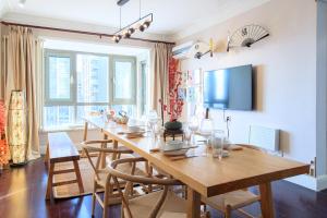 a dining room with a large wooden table and chairs at Tianjin Nankai·Drum tower in Tianjin