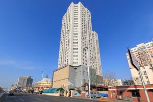 a tall white building on the side of a street at Tianjin hexi diatrict culture centre in Tianjin