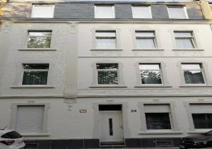 een wit gebouw met veel ramen aan een straat bij Kölsche Wohnung 1C in Keulen