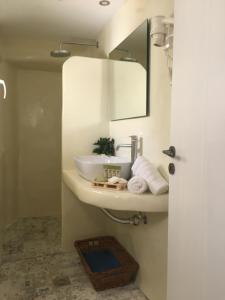 een badkamer met een wastafel en een spiegel bij Langas Villas in Imerovígli