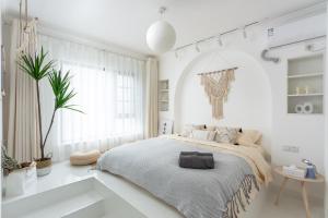 a white bedroom with a large bed and a bathtub at Wuhan City Wuchang District shahu park in Hankou
