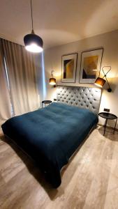 a bedroom with a large bed with a blue blanket at Apartament Victoria 5 Mórz in Sianozety