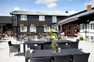a patio with tables and chairs in front of a building at Gomobu Fjellstue in Ron