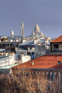 a view of a city with buildings and roofs at Hotel de Neuville Arc de Triomphe in Paris