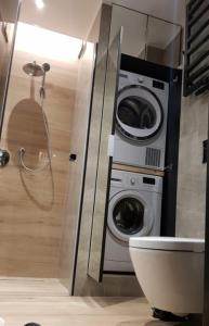 y baño con lavadora junto a un aseo. en Apartament green-balcony z parkingiem i rowerami en Świnoujście