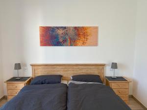 ein Schlafzimmer mit 2 Betten und einem Wandgemälde in der Unterkunft Ferienwohnung Weinbergblick in Mehring