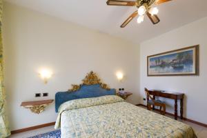 a bedroom with a bed, lamp and a painting on the wall at Hotel Porto Roca in Monterosso al Mare