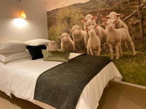 Le Mouton à 5 Pattes Aubagne-Cassis-Aix en Provence في أوباني: غرفة نوم فيها قطيع من الأغنام تقف على السرير