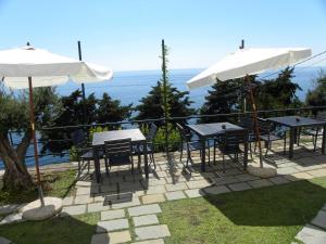 a patio with tables and chairs and umbrellas at Corte Del Gallo in Corniglia