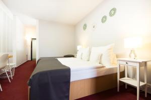 ミクロフにあるホテル マロリ ミクロフのベッドとテーブルが備わるホテルルームです。