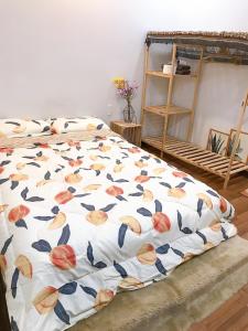 a bed with a floral comforter in a room at 1993’s house in Ho Chi Minh City