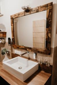 a bathroom with a white sink and a mirror at Hotel Goldene Steig in Kempten