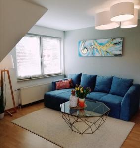 een woonkamer met een blauwe bank en een tafel bij Bernstein in Zingst