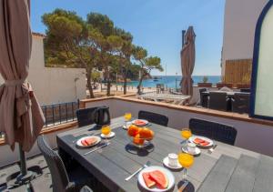 einen Tisch mit Obst auf einem Balkon mit Blick auf den Strand in der Unterkunft Gala 2 in Tamariu