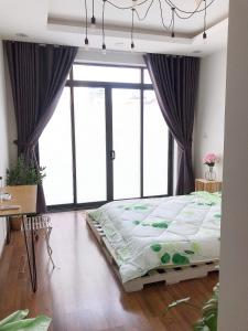 a large bed in a room with large windows at 1993’s house in Ho Chi Minh City