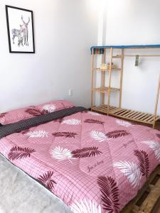a bedroom with a pink bed with a pink and white blanket at 1993’s house in Ho Chi Minh City