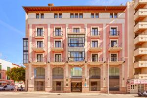 un grand bâtiment rose avec de nombreuses fenêtres dans l'établissement Bordoy Continental Palma, à Palma de Majorque