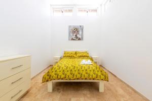 a bedroom with a bed with a yellow bedspread at VILLA ROA in Roatan +37 photos