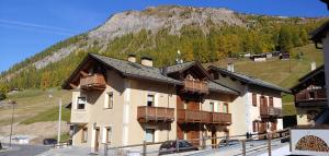 a large building with wooden balconies and a mountain at Real Wood Pemont Myholidaylivigno in Livigno