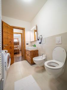 a bathroom with a toilet and a sink and a tub at Real Wood Pemont Myholidaylivigno in Livigno
