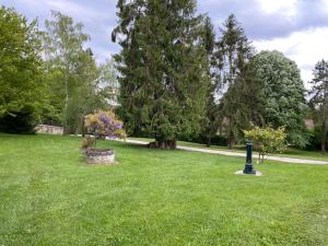 a green field with a park with trees and a street light at Dépendance cosy dans le Vexin, terrasse et jardin in Us +1 photo