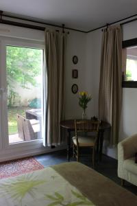 1 dormitorio con mesa y ventana con vistas al patio en Le Garden Victoria - Canal & Cathédrale -30m2 & Garden, en Nancy
