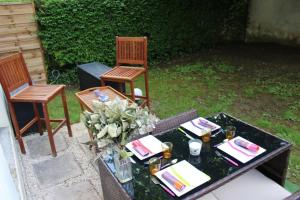 un tavolo con due sedie e un vaso di fiori di Le Garden Victoria - Canal & Cathédrale -30m2 & Garden a Nancy