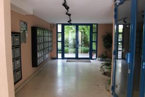 un corridoio vuoto con una grande porta a vetri e una stanza con di Le Garden Victoria - Canal & Cathédrale -30m2 & Garden a Nancy