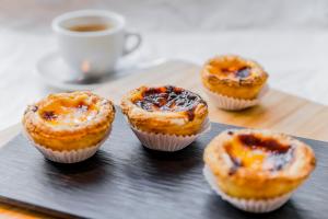 a group of muffins on a tray with a cup of coffee at HF Ipanema Park in Porto