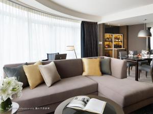 a living room with a couch and a dining room at Royal Plaza Hotel in Hong Kong