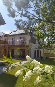 a house with white flowers in front of it at Słoneczna Sarbinówka in Sarbinowo
