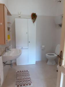 a white bathroom with a toilet and a sink at Agriturismo VILLA MOZART nel verde in Gubbio
