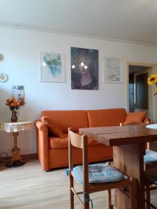 グッビオにあるAgriturismo VILLA MOZART nel verdeのリビングルーム(オレンジ色のソファ、テーブル付)