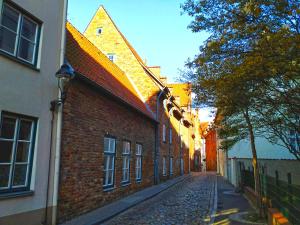 a brick building with a clock on the side of it at Altstadt-Hostel CVJM Lübeck in Lübeck