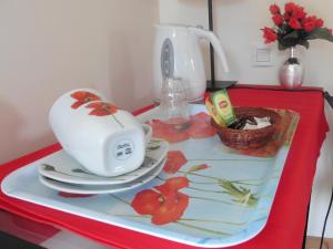 una mesa roja con un hervidor de agua y platos. en B&B Le Bois Berranger, en Saint-Urbain