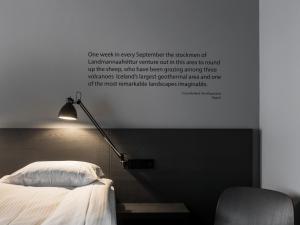 a wall with a picture of a bed and a lamp at Skuggi Hotel by Keahotels in Reykjavík