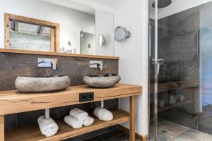 a bathroom with two sinks and a shower at Relais & Châteaux Gut Steinbach Hotel Chalets SPA in Reit im Winkl
