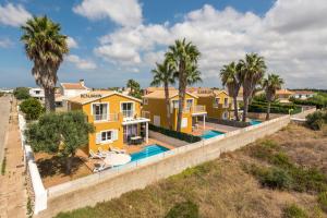 Casa amarilla con piscina y palmeras en Samuel y Benjamin, en Ciutadella
