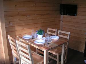 a wooden table with chairs and plates on it at Wantaris - domki letniskowe z ogródkiem Mielno-Mielenko in Mielno +20 photos