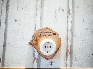 un enchufe en una pared de madera con un cartel. en Posada Peñarubia, en Peñarrubia