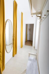un pasillo con cortinas amarillas y espejo en Rosenstein Apartments by Family & Home, en Viena