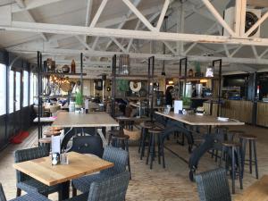 a restaurant with tables and chairs in a room at STRAND 21 hotelchalets in Zandvoort