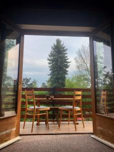 a wooden table and chairs on a porch with a window at Chata se zahradou in Týnec nad Labem