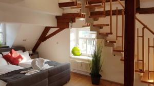 a living room with a couch and a spiral staircase at Apartment Pegnitzmühle mit Pegnitzinsel in Vorra
