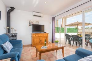 a living room with blue chairs and a tv and a table at Samuel y Benjamin in Ciutadella