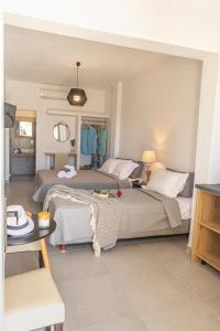 a bedroom with two beds and a table at Fragoulis Village in Parasporos