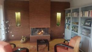 a living room with a fireplace and a brick wall at Domaine La Source in Ouirgane